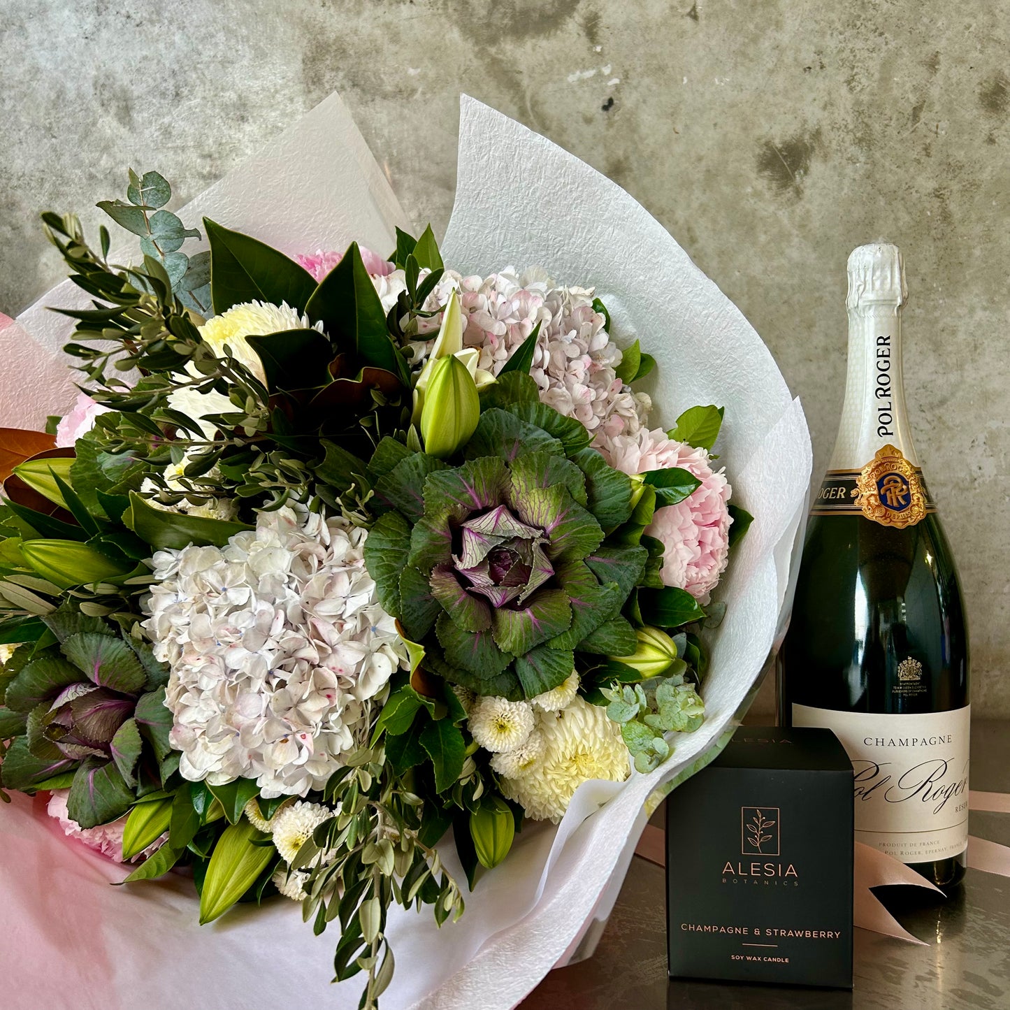 Blooms Scent and Sparkle gift set with seasonal bouquet in soft romantic tones, Alesia Botanics scented candle and premium French champagne.