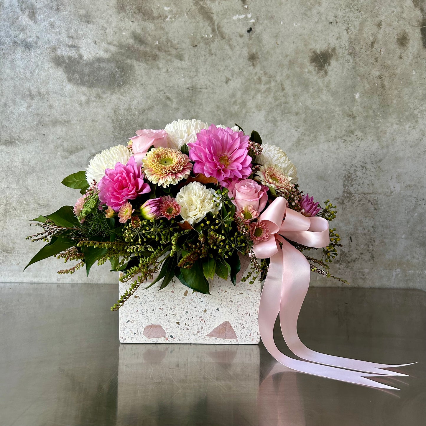 Osaka soft blush classic box arrangement with pink dahlias, ruffled roses, creamy carnations and whimsical blooms in a timeless vessel with satin ribbon.